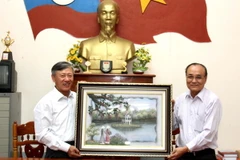Đại sứ Việt Nam tại Lào Nguyễn Mạnh Hùng tặng tranh. (Ảnh: Hoàng Chương/Vietnam+)