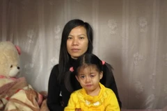 Vợ và con Hùng đang mong ngóng được đón anh về (Ảnh: Nguyễn Văn Nhật/Vietnam+)