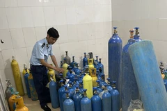 Lực lượng Quản lý Thị trường Hà Nội phát hiện một cơ sở san chiết khí N2O trái phép. (Ảnh: Đức Duy/Vietnam+)