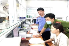 Lực lượng chức năng tiến hành khám xét các phòng khám đa khoa có liên quan. (Ảnh: TTXVN)