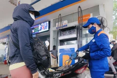 Nhân viên Petrolimex đang bán xăng cho khách hàng. (Ảnh: Đức Duy/Vietnam+)