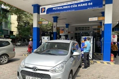 Nhân viên Petrolimex bán xăng cho khách hàng. (Ảnh: Đức Duy/Vietnam+)