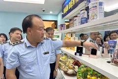 Ông Trần Hữu Linh, Tổng cục trưởng Tổng cục Quản lý Thị trường hướng dẫn cách nhận biết nhãn hiệu được bảo hộ tại Việt Nam. (Ảnh: Xuân Quảng/Vietnam+)