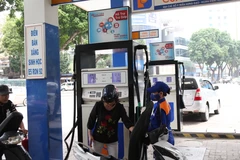 Nhân viên Petrolimex bán xăng cho khách hàng. (Ảnh: Đức Duy/Vietnam+)