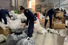 Lực lượng chức năng kiểm tra cơ sở nghi sản xuất bít tất giả nhãn hiệu được bảo hộ trên địa bàn huyện Đông Anh, Hà Nội. (Ảnh: PV/Vietnam+)