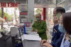 Đội Quản lý thị trường số 4 phối hợp với Công an quận Đống Đa kiểm tra thiết bị đo nồng độ cồn tại phố Phương Mai, Hà Nội. (Ảnh: PV/Vietnam+)