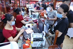 Khách hàng giao dịch vàng miếng. (Ảnh: PV/Vietnam+)
