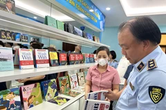 Ông Trần Hữu Linh, Tổng cục trưởng Tổng cục Quản lý thị trường hướng dẫn cách phân biệt một số sản phẩm vi phạm sở hữu trí tuệ. (Ảnh: Xuân Quảng/Vietnam+)