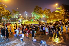Người dân một số nơi xếp hàng lấy nước sạch. (Ảnh: PV/Vietnam+)