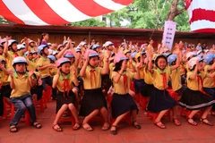 Học sinh đội mũ bảo hiểm đạt chuẩn để đảm bảo an toàn giao thông. (Ảnh: Việt Hùng/Vietnam+)