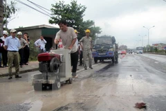 Nhà thầu thi công sửa chữa hư hỏng, hằn lún vệt bánh xe tuyến Quốc lộ 5. (Ảnh: Phan Quân/TTXVN)