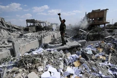 Một người lính Syria chụp ảnh tại đống đổ nát ở Trung tâm nghiên cứu khoa học gần Damascus (Nguồn: AP)