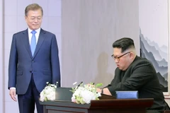 Nhà lãnh đạo Triều Tiên Kim Jong-un (phải) viết sổ lưu bút trước cuộc hội đàm thượng đỉnh với Tổng thống Hàn Quốc Moon Jae-in ở làng đình chiến Panmunjom. (Nguồn: Yonhap/TTXVN)