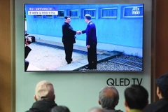 Người dân Hàn Quốc theo dõi hình ảnh Tổng thống Hàn Quốc Moon Jae-in (phải) đón Nhà lãnh đạo Triều Tiên Kim Jong-un ở đường phân định ranh giới giữa hai miền tại làng đình chiến Panmunjom. (Nguồn: AFP/TTXVN)