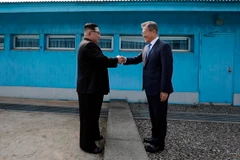 Tổng thống Hàn Quốc Moon Jae-in (phải) đón Nhà lãnh đạo Triều Tiên Kim Jong-un ở đường phân định ranh giới giữa hai miền tại làng đình chiến Panmunjom. (Nguồn: TTXVN)