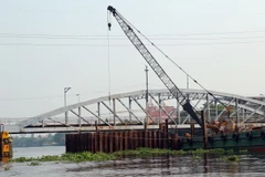 Thi công mới cầu sắt Bình Lợi để nâng tĩnh không thông thuyền của cầu hiện nay từ 1,5m lên 7m. (Ảnh: Huy Hùng/TTXVN)