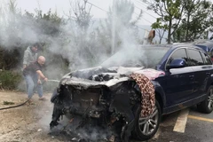 Người dân kéo ống nước tới vị trí xe gặp nạn và dập tắt đám cháy. (Nguồn: Báo Công an nhân dân)