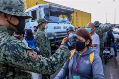 Cảnh sát kiểm tra thân nhiệt của người dân tại một điểm kiểm soát ở Quezon, Philippines ngày 17/3/2020, trong bối cảnh dịch COVID-19 lan rộng. (Nguồn: THX/TTXVN) 
