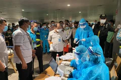Nhân viên y tế làm thủ tục lấy mẫu xét nghiệm cho người làm việc tại sân bay Tân Sơn Nhất, ngày 6/2. (Nguồn: TTXVN phát) 