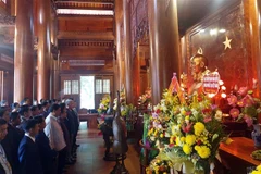 Các trưởng bản tiêu biểu hai nước Việt-Lào thành kính tưởng niệm trước anh linh Chủ tịch Hồ Chí Minh. (Ảnh: Tá Chuyên/TTXVN) 