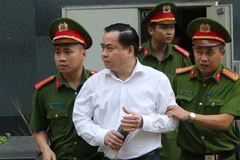 Cảnh sát dẫn giải bị cáo bị cáo Phan Văn Anh Vũ (sinh năm 1975, Chủ tịch Hội đồng quản trị Công ty cổ phần Xây dựng 79, Công ty cổ phần Bắc Nam 79) về trại giam. (Ảnh: Doãn Tấn/TTXVN) 