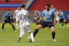 Messi với pha đi bóng vượt qua tiền đạo Luis Suarez (Uruguay). (Nguồn: Reuters) 