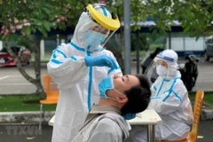 Các y bác sỹ Trung tâm kiểm soát bệnh tật Thành phố Hồ Chí Minh và quận 7 thực hiện xét nghiệm sàng lọc COVID-19 ngẫu nhiên hồi tháng 6/2021. (Ảnh: Thanh Vũ/TTXVN) 