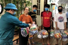 Những phần quà hỗ trợ được kịp thời chuyển tới các hộ dân có hoàn cảnh khó khăn trong khu vực phong tỏa. (Nguồn: TTXVN) 