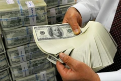 Nhân viên kiểm đồng USD tại ngân hàng ở Seoul, Hàn Quốc. (Ảnh: AFP/TTXVN) 