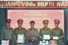 Đại tá Lê Việt Thắng, Giám đốc Công an tỉnh Bạc Liêu (đứng giữa), trao thưởng cho Ban chuyên án. (Ảnh: Hải Linh/TTXVN phát)