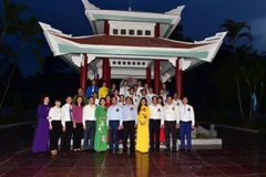 Các đại biểu chụp ảnh lưu niệm tại khu nhà bia kỷ niệm của Ban Tổ chức Trung ương. (Ảnh Quang Cường/TTXVN) 
