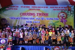 Tặng quà cho trẻ em có hoàn cảnh khó khăn. (Ảnh: Lê Sen/TTXVN)