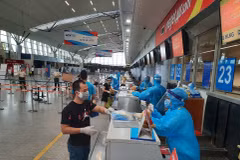 Nhân viên mặt đất của Hãng hàng không Vietjet phát quần áo bảo hộ miễn phí cho hành khách rời Đà Nẵng. (Nguồn: Vietnam+) 
