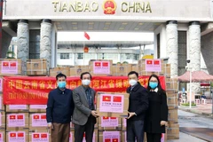 Lãnh đạo Sở Ngoại vụ, Sở y tế tỉnh Hà Giang tiếp nhận vật tư y tế do châu Văn Sơn, tỉnh Vân Nam (Trung Quốc) trao tặng. (Ảnh: Nguyễn Chiến/TTXVN) 