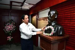 Tổng Lãnh sự Hoàng Ngọc Vinh dâng hoa lên tượng Hồ Chủ tịch đặt tại Nhà ở cũ của Người. (Ảnh: Tổng Lãnh sự quán Việt Nam tại Nam Ninh cung cấp) 