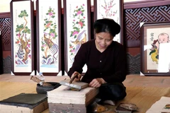 Trình diễn nghề làm tranh dân gian Đông Hồ. (Ảnh: Đinh Văn Nhiều/TTXVN)