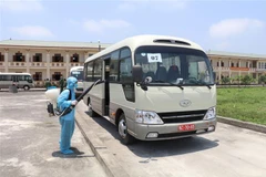Thực hiện khử khuẩn xe chở các công dân đến khu cách ly. (Ảnh: Đức Phương/TTXVN) 