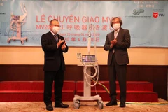 Ông Trần Ngọc Phúc (phải) bàn giao máy thở cho Đại sứ Vũ Hồng Nam. (Ảnh: Đức Thịnh/TTXVN)