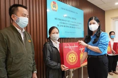 Lãnh đạo Liên đoàn Lao động thành phố tặng quà cho đoàn viên công đoàn, người lao động bị ảnh hưởng do dịch COVID-19 trên địa bàn quận Hoàn Kiếm. (Ảnh TTXVN phát) 