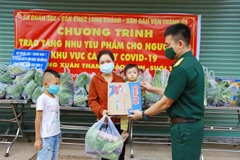 Lực lượng bộ đội thuộc Sư đoàn 302-Quân khu 7 gửi tặng nhu yếu phẩm cho người dân đang thực hiện cách ly tại nhà ở phường Xuân Thanh (Cẩm Mỹ, Đồng Nai). (Ảnh: Lê Xuân/TTXVN) 