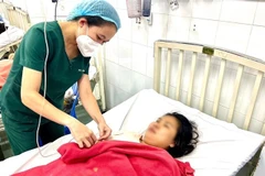 Bác sỹ thăm khám cho sản phụ sau ca sinh non do sốt xuất huyết. (Ảnh: TTXVN phát) 