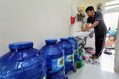 Trung bình mỗi tháng, người dân sống tại hẻm 111, đường Võ Văn Kiệt phải chi thêm khoảng 200 nghìn đồng để mua nước lọc dùng cho ăn uống. (Ảnh: Thanh Liêm/TTXVN) 