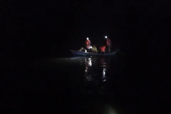 Lực lượng cứu nạn tìm kiếm hai công nhân còn mất tích xuyên đêm. (Ảnh: Xuân Triệu/TTXVN)