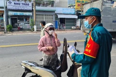 Lực lượng chức năng vận động người dân quay trở lại nơi tạm trú. (Ảnh: Chí Tưởng/TTXVN) 