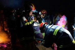 Lực lượng cứu hộ hỗ trợ người bị thương do thời tiết thay đổi bất ngờ trong cuộc chạy marathon ở tỉnh Cam Túc, Trung Quốc, ngày 23/5/2021. (Nguồn: AFP/TTXVN) 