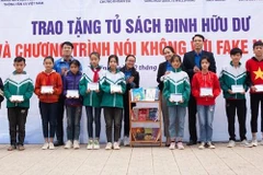 Trao tặng biểu trưng Tủ sách Đinh Hữu Dư cho trường THCS Trần Kim Xuyến. (Ảnh: Hoàng Ngà/TTXVN) 