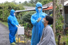 Nhân viên Y tế Bệnh viện Triều An-Loan Trâm (tỉnh Vĩnh Long) hỗ trợ huyện Long Hồ lấy mẫu xét nghiệm COVID-19 cho các hộ gia đình công nhân và tiểu thương. (Ảnh: Lê Thúy Hằng/TTXVN) 