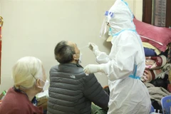 Nhân viên y tế lấy mẫu xét nghiệm cho người dân phường Cửa Đông, quận Hoàn Kiếm, Hà Nội. (Ảnh: Minh Quyết/TTXVN) 