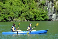 Du khách trải nghiệm chèo thuyền kayak, thuyền tay trên vịnh Hạ Long. (Ảnh: Thanh Vân-TTXVN)