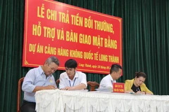 Người dân làm thủ tục nhận tiền đền bù, hỗ trợ hôm 18/5. (Ảnh: Công Phong/TTXVN) 